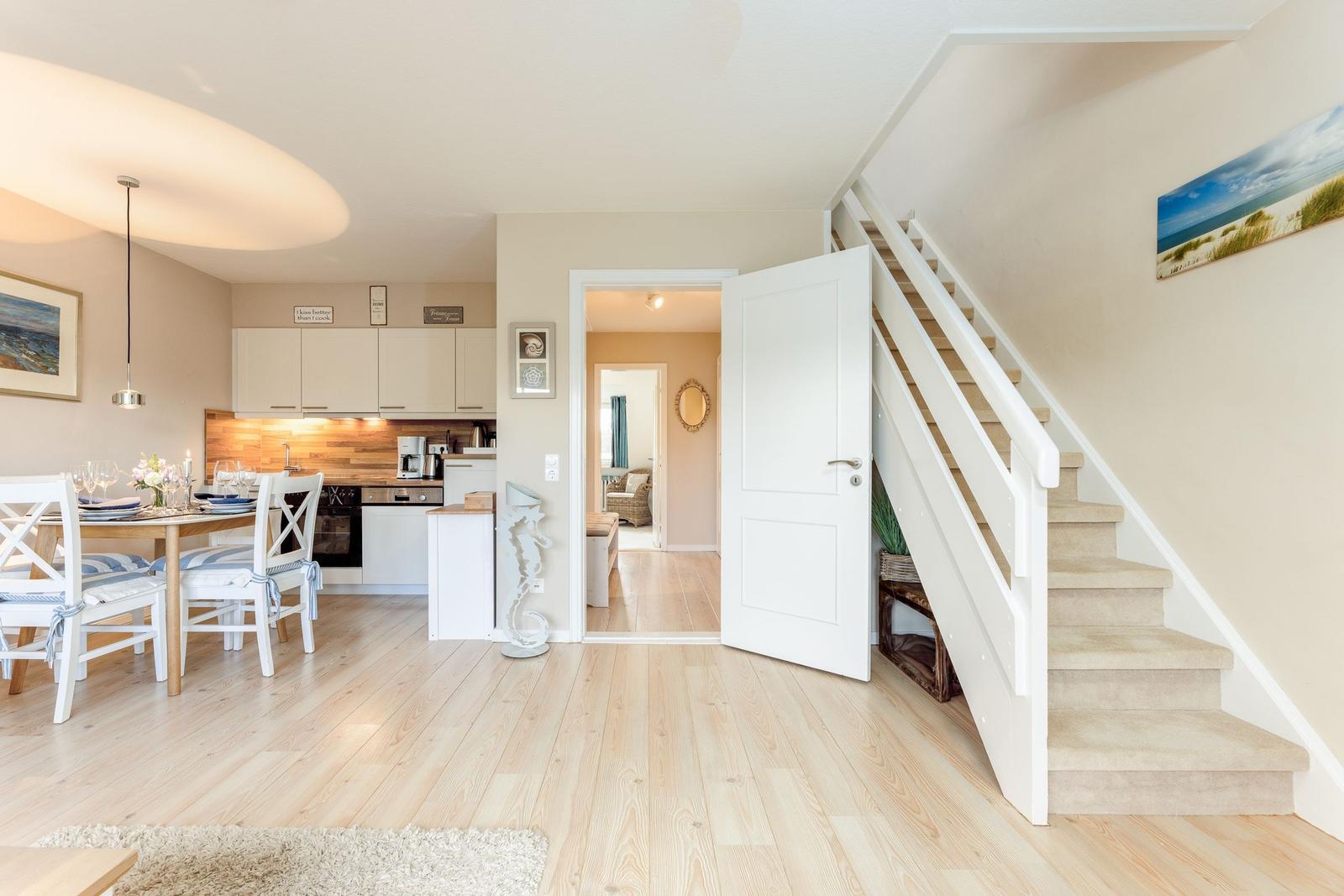 Wohnung mit Essbereich, Küche und Treppe zur oberen Etage.