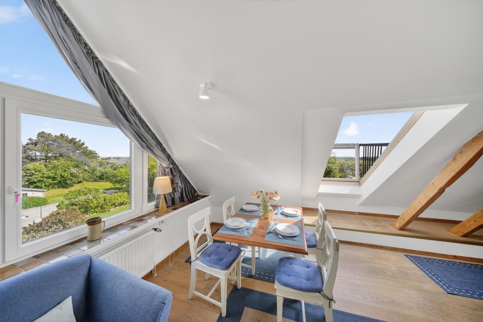 Dachgeschosses mit Tisch, Stühlen und Blick auf Garten
