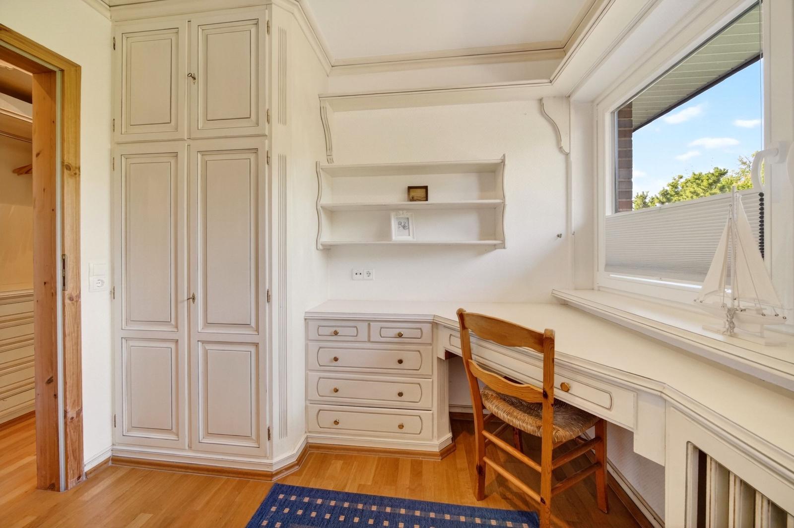 Schreibtischbereich mit Kleiderschrank und Fenster