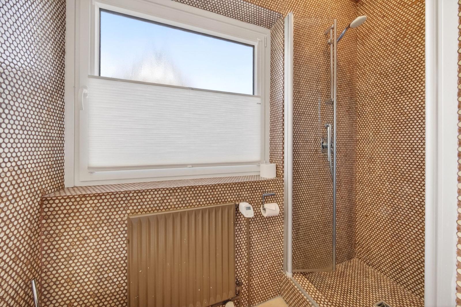 Bad mit Dusche und Fenster mit Jalousie