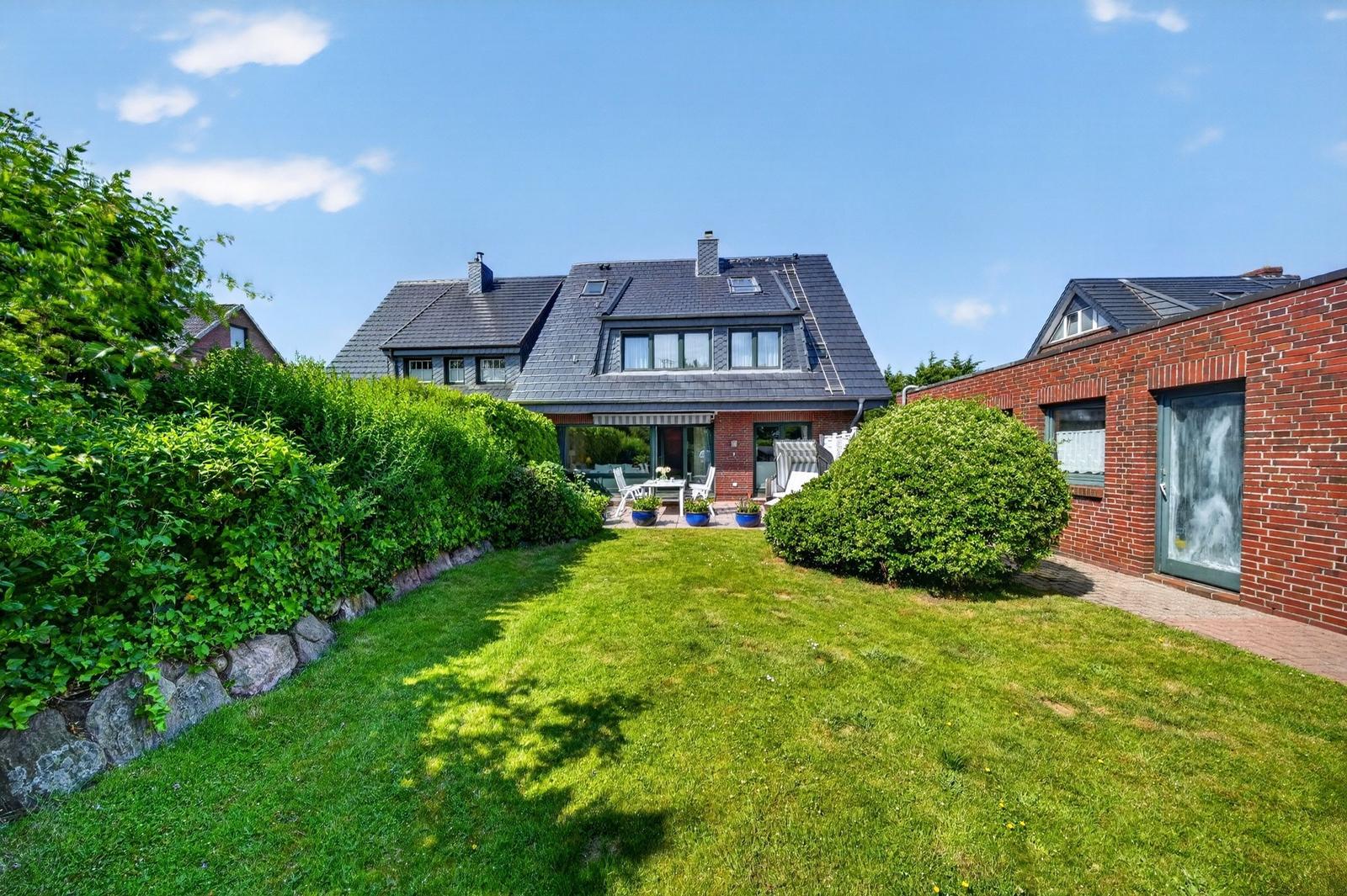 Haus mit Garten, Terrasse und Grillplatz. Roter Backsteinbau mit Dachgauben.