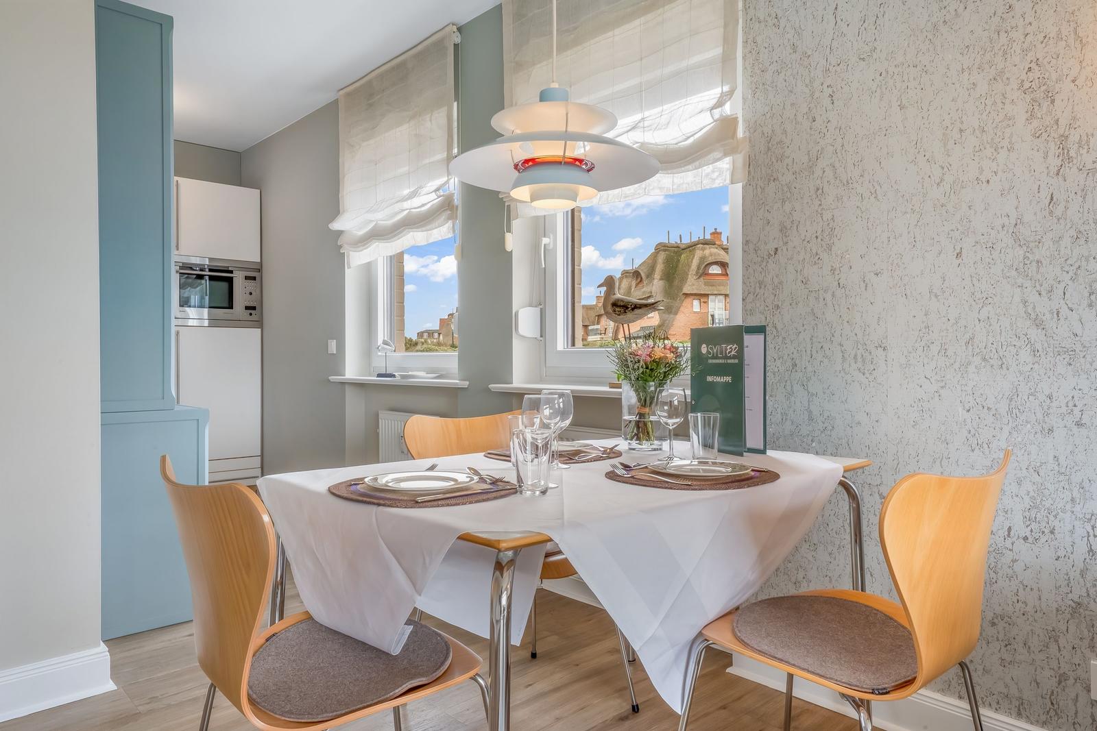 Essbereich mit Tisch, Stühlen und Fensterblick auf Dächer