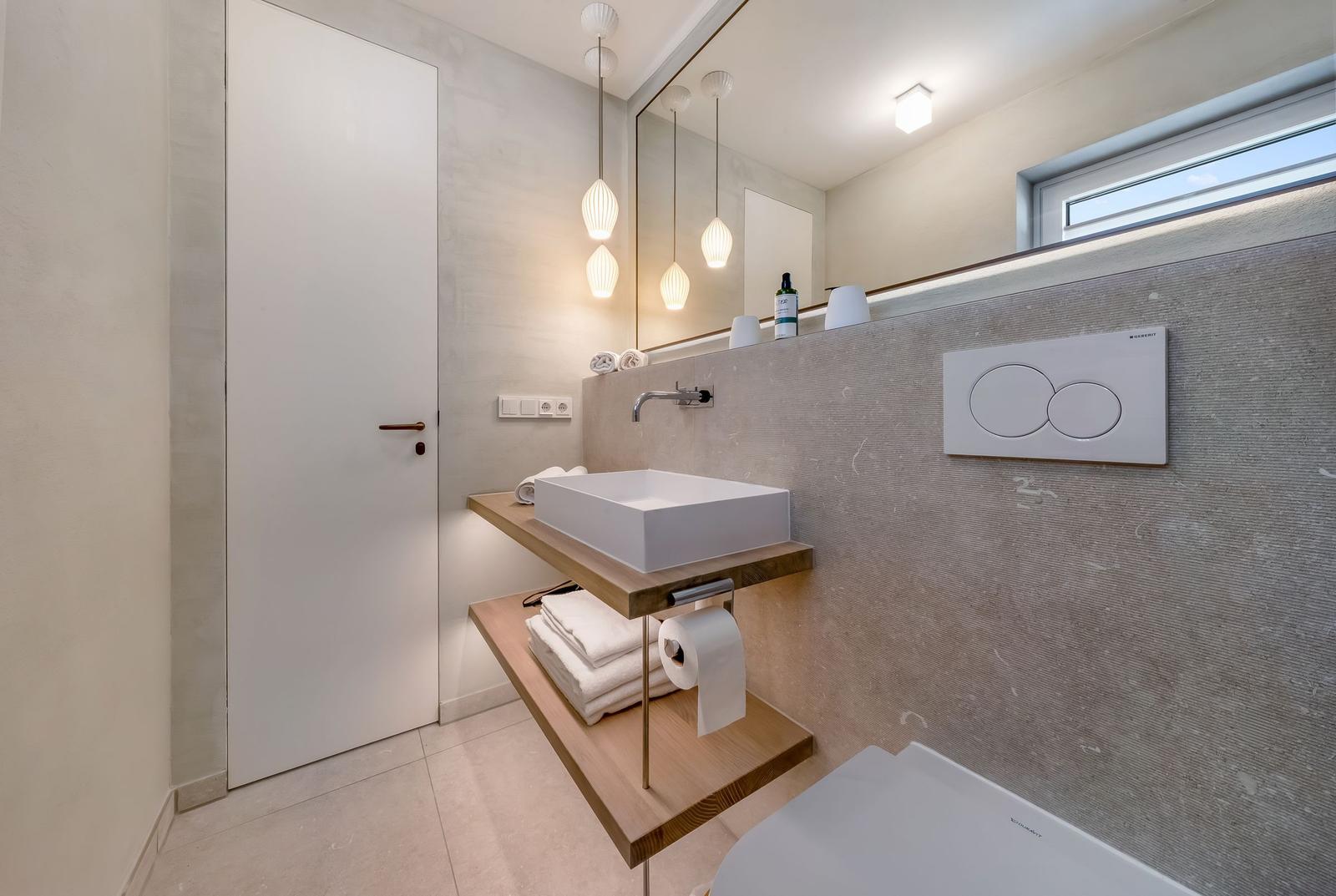 Moderne Badewanne mit Waschbecken, Spiegel und Fenster.
