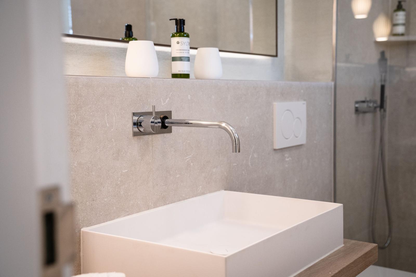 Waschbecken mit Wasserhahn und Spiegelschrank