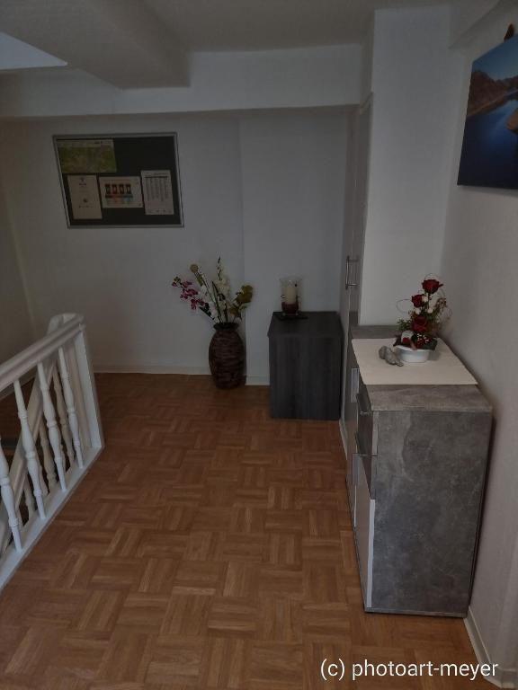 Eingangsbereich mit Holzboden, Vase mit Blumen und Küchenschränken