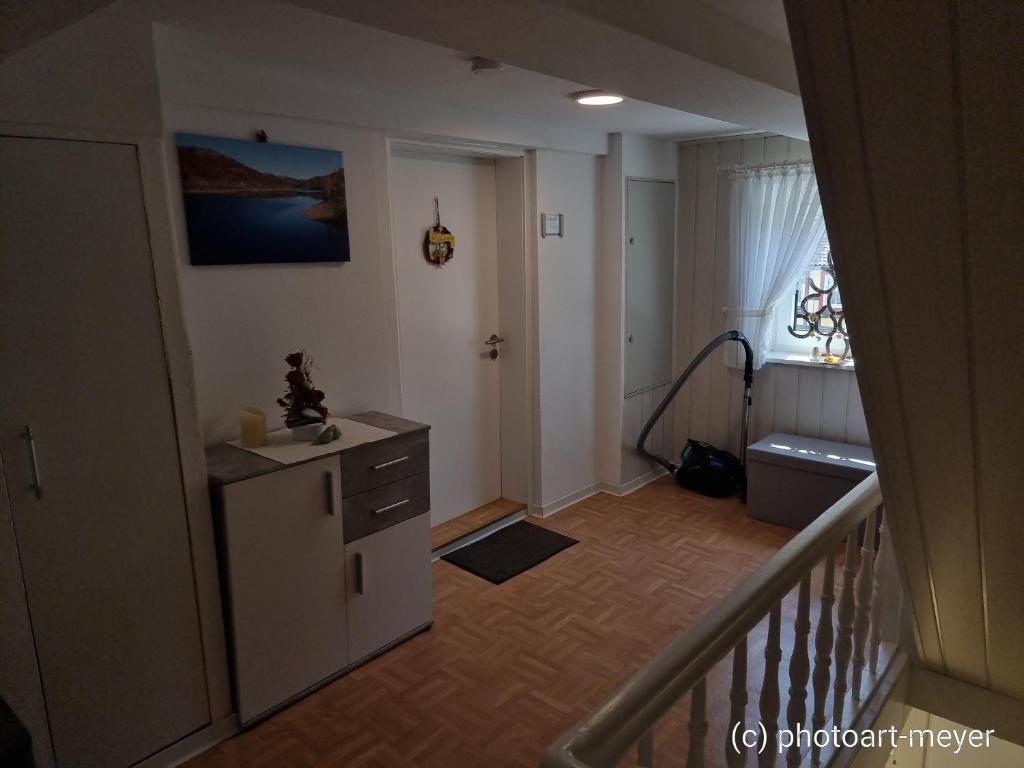 Eingangsbereich mit Schrank, Wandbild und Fenster mit Vorhängen.