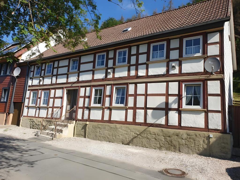 Fachwerkhäuser mit Steinsockel und Dachgaube. Satellitenschüssel an der Fassade.