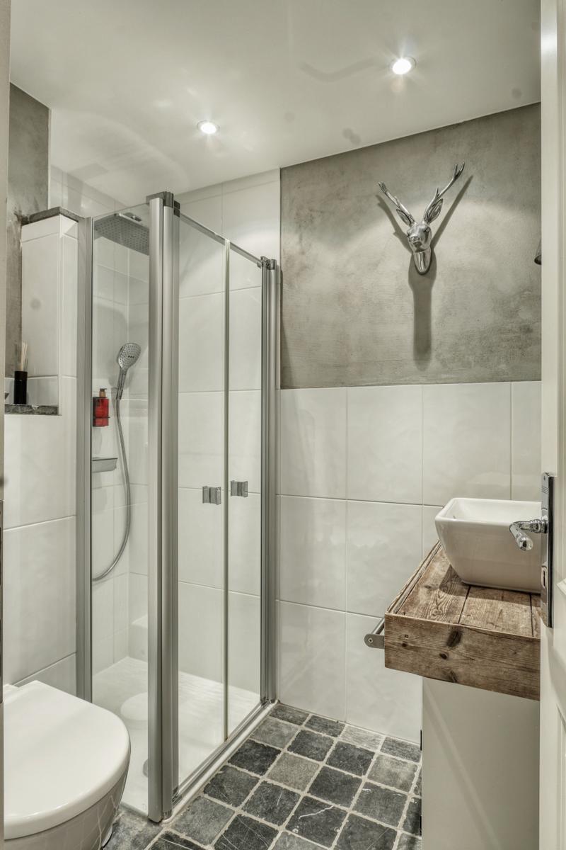 Badezimmer mit Dusche, Waschbecken auf Holz und Wanddekoration