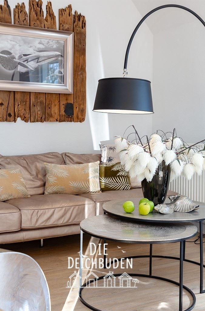 Ein Wohnzimmer mit Sofa, Tisch und Lampe. An der Wand hängt ein Bild.