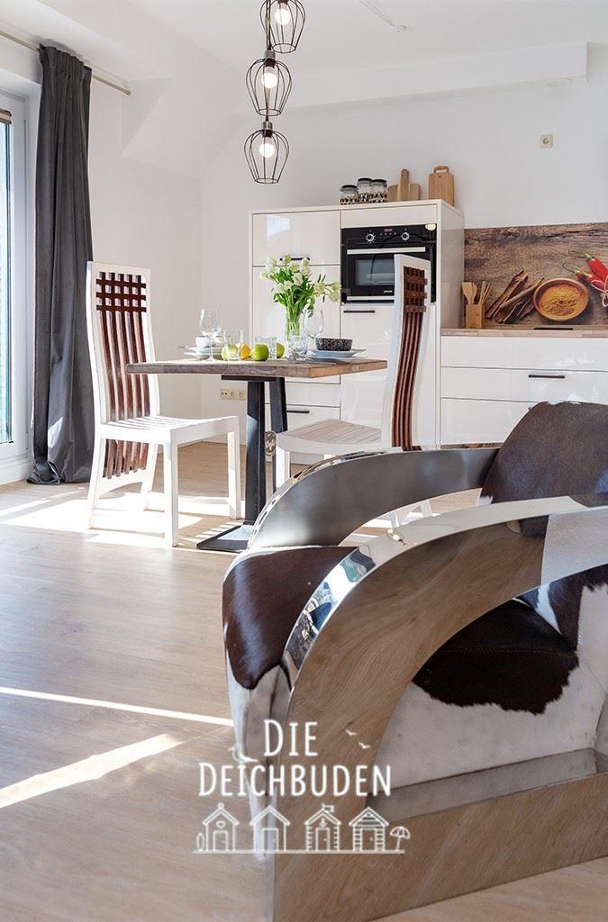 Esszimmer mit Tisch, Stühlen und moderner Küchenzeile.