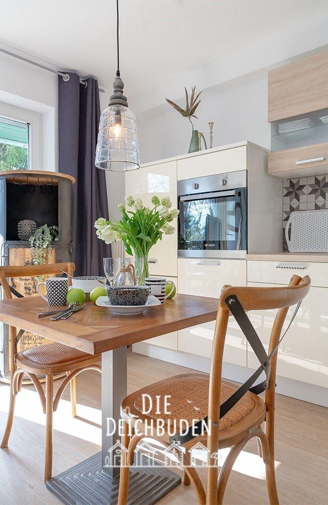 Küche mit Esstisch, Holzstühlen und integriertem Ofen.