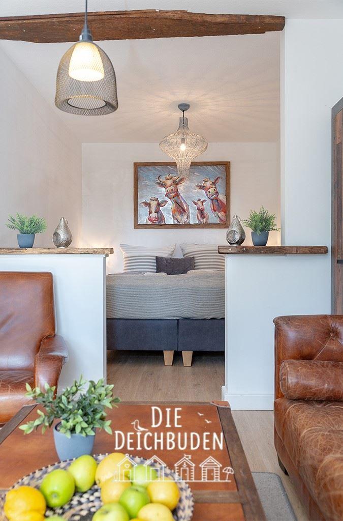 Wohnbereich mit Ledersofa, Bett und Gemälde an der Wand