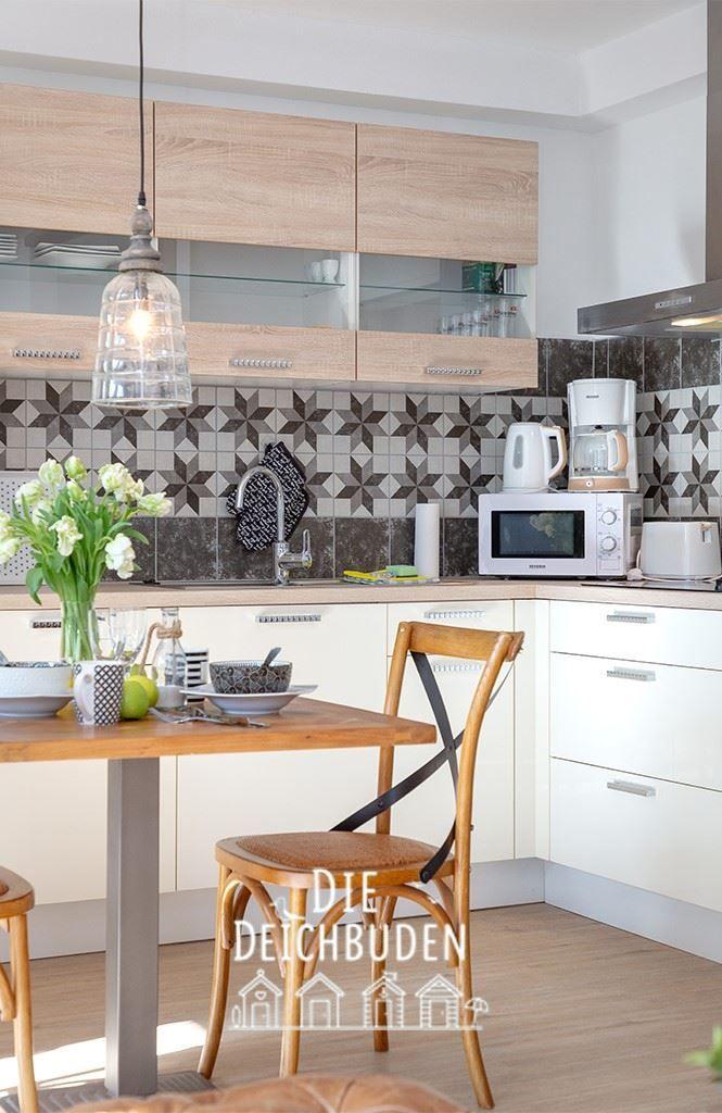 Küche mit Holzschrank, Mosaikwand und Esstisch mit Stuhl