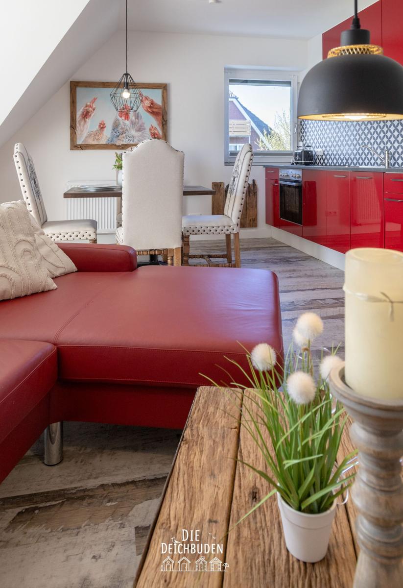 Roter Ledersofa im Wohnbereich mit Essbereich und roter Küche.