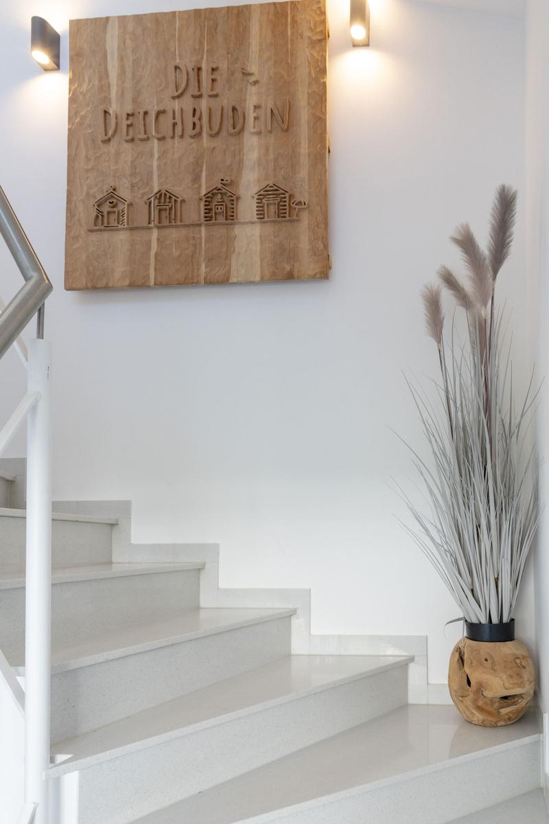 Treppenhaus mit Holzschild und Pflanze