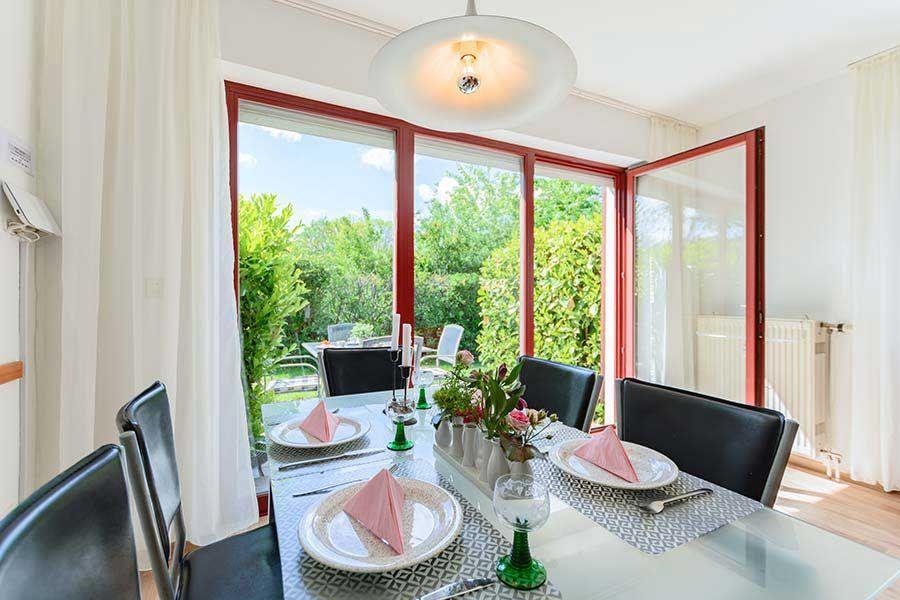 Esszimmer mit Tisch, Stühlen und Blick auf Garten