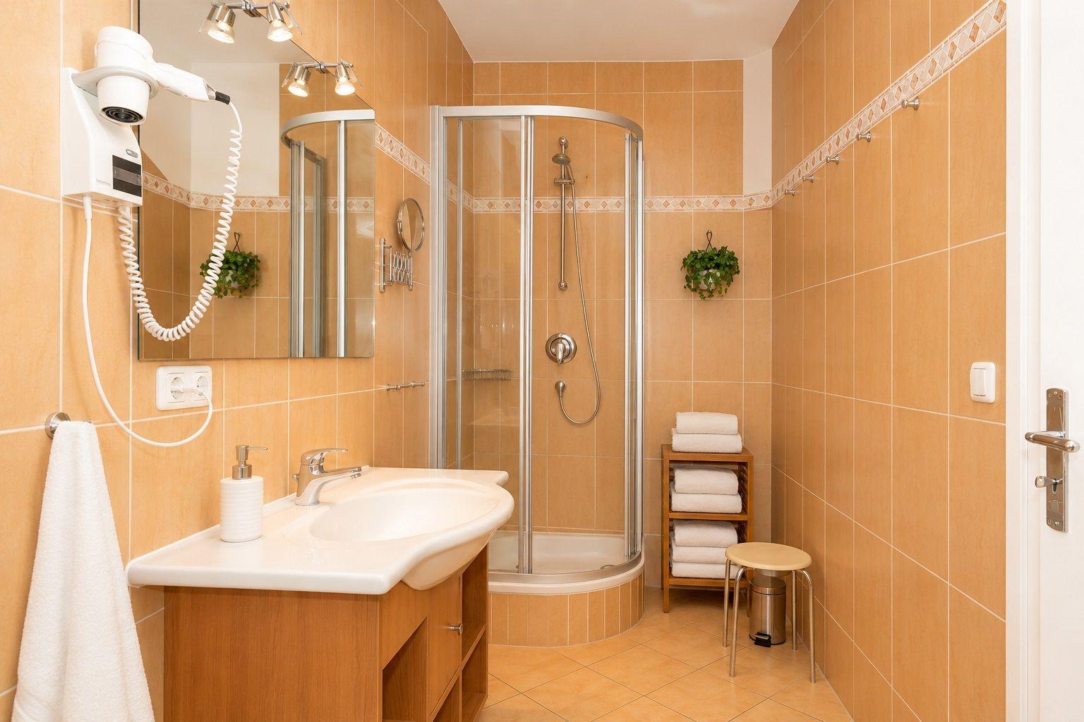 Bad mit Dusche, Waschbecken und Handtuchständer.