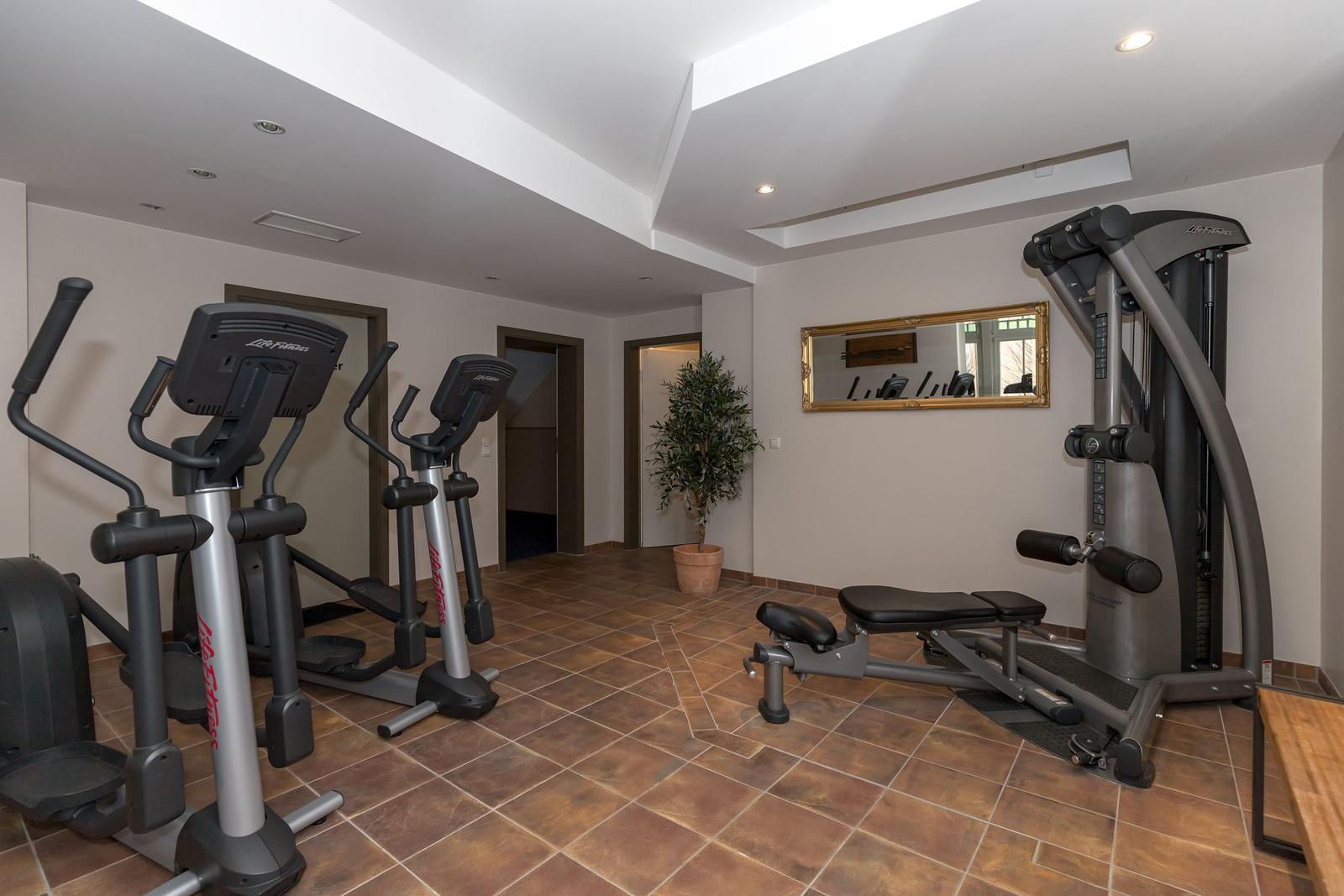 Fitnessraum mit Laufbändern und Kraftmaschinen auf Fliesenboden