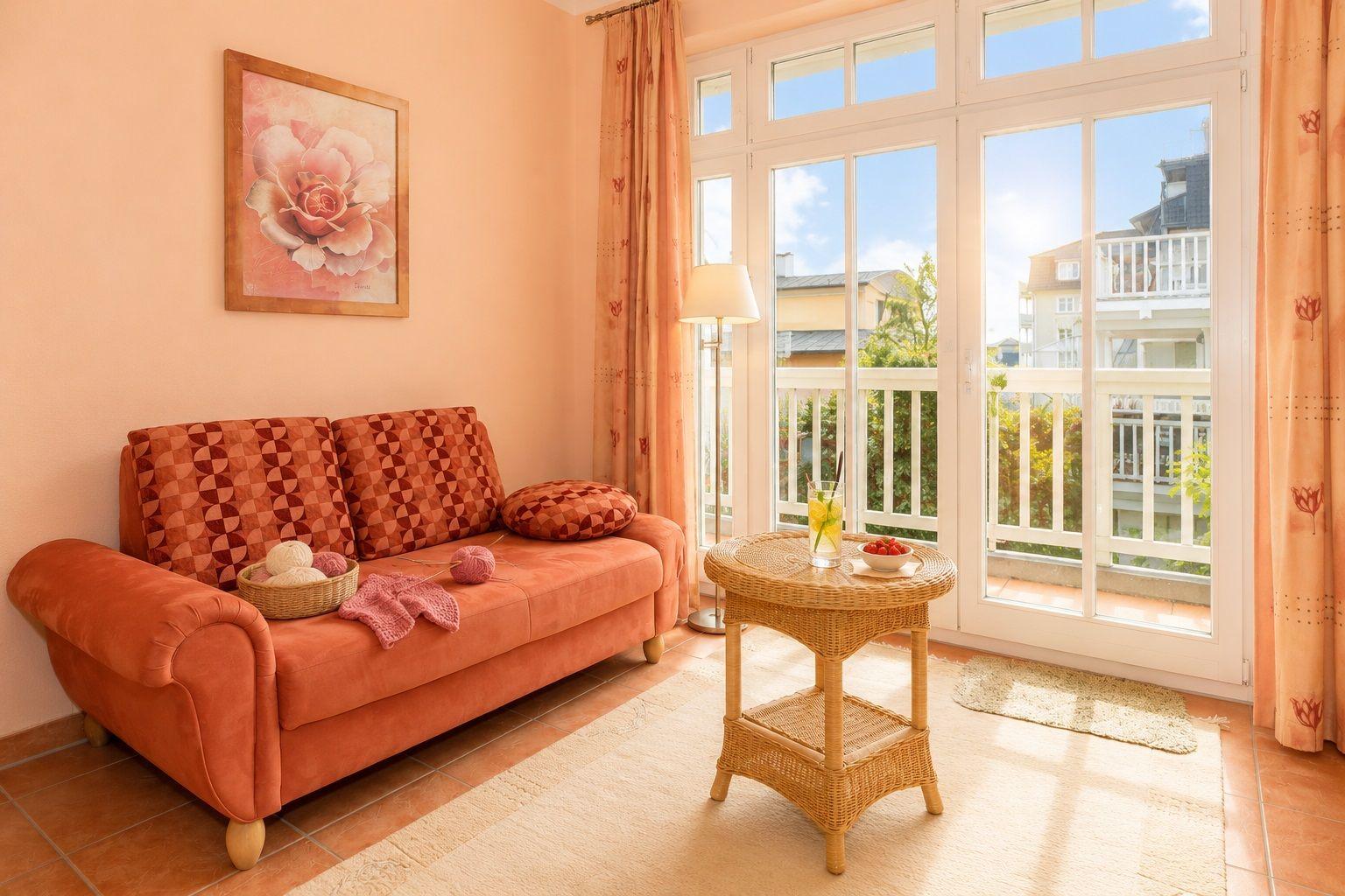 Ein Wohnzimmer mit Sofa, Tisch und Balkon. Wandbild und Vorhänge sind rosa.