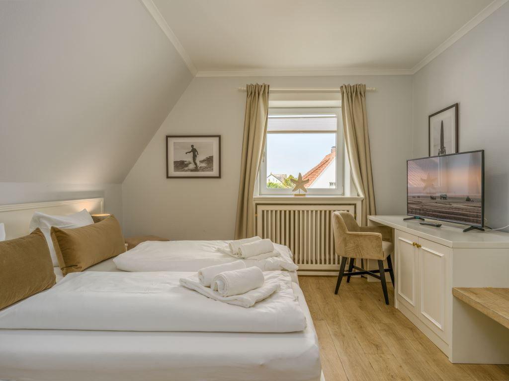 1. Schlafzimmer mit TV und Schreibtisch.