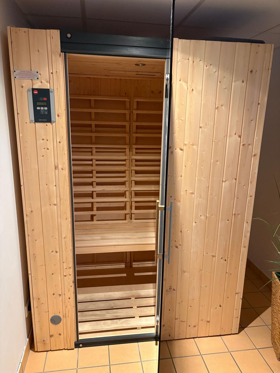 Sauna mit Holzverkleidung und Bedienfeld an der Tür