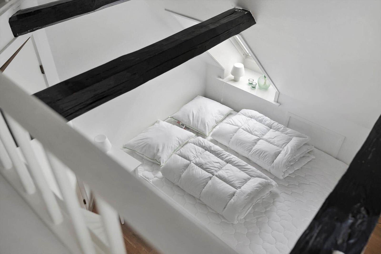 Bedroom with double bed, window, and black beams.