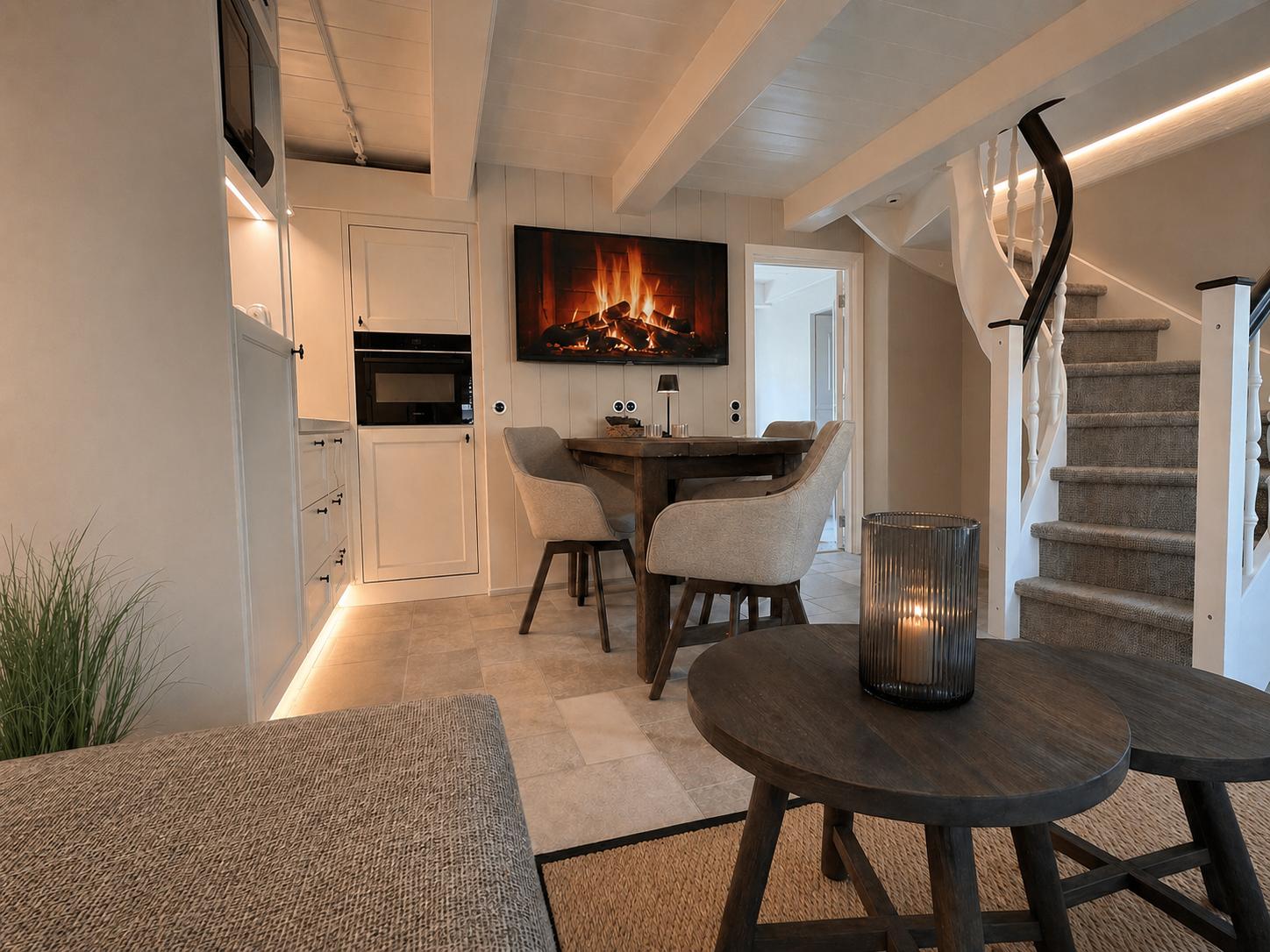 Essbereich mit Tisch, Stühlen und Treppenaufgang. Wandbild zeigt Kamin.