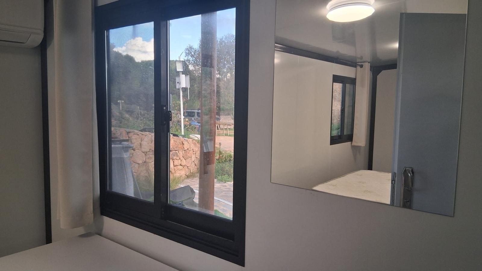 Bedroom with window and mirror on the wall