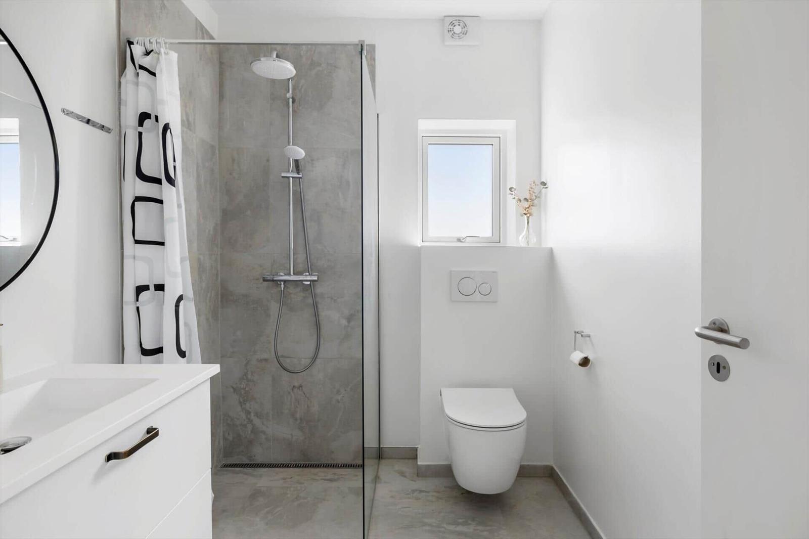 Badezimmer mit Dusche, Toilette und Waschbecken.