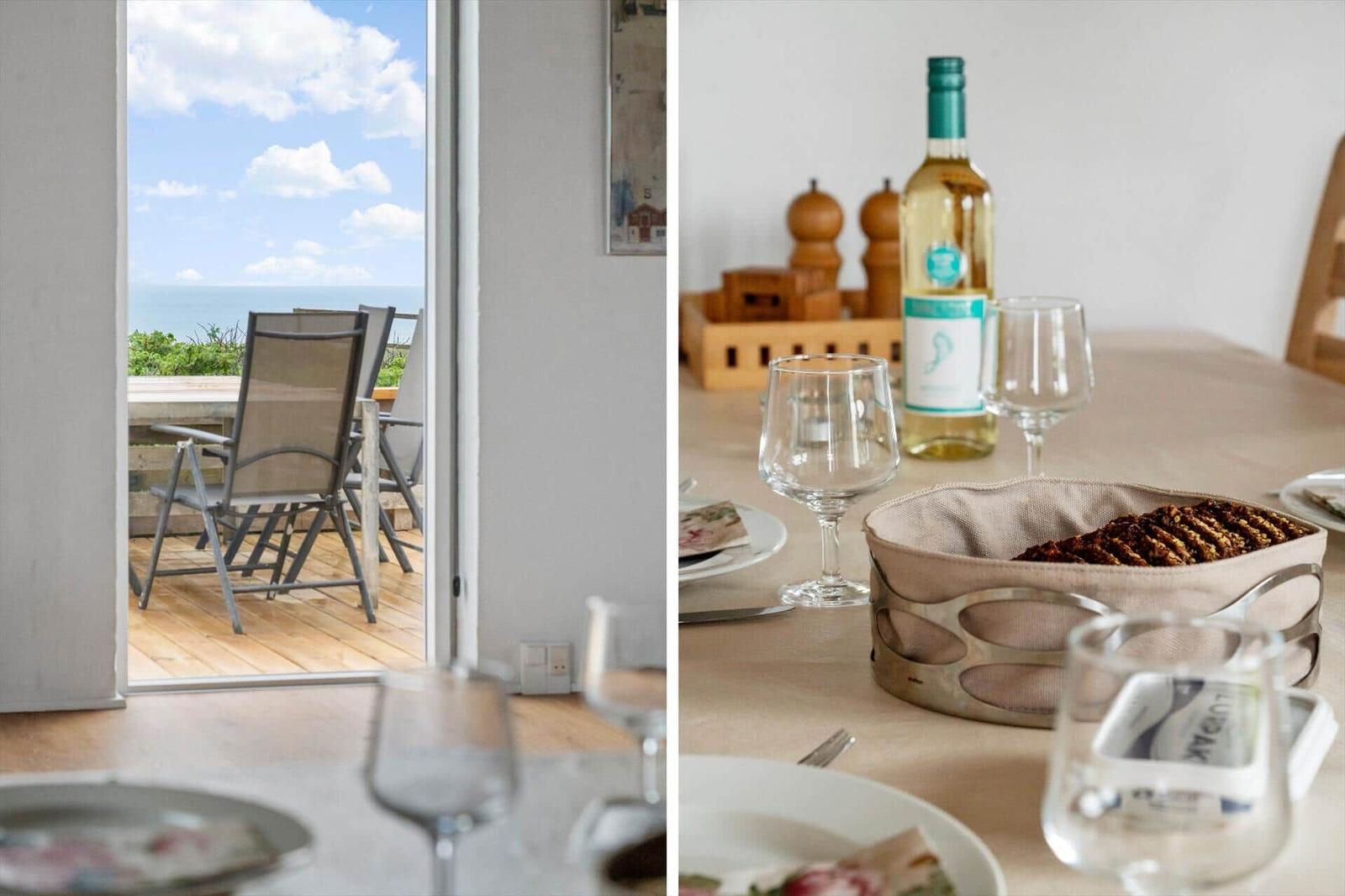 Terrace with sea view and set table with wine and biscuits.