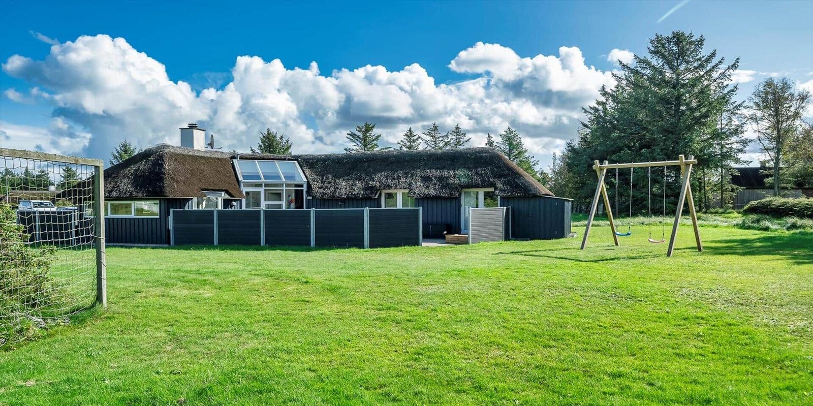 Haus mit Strohdach, großer Garten mit Schaukel und Fußballtor.