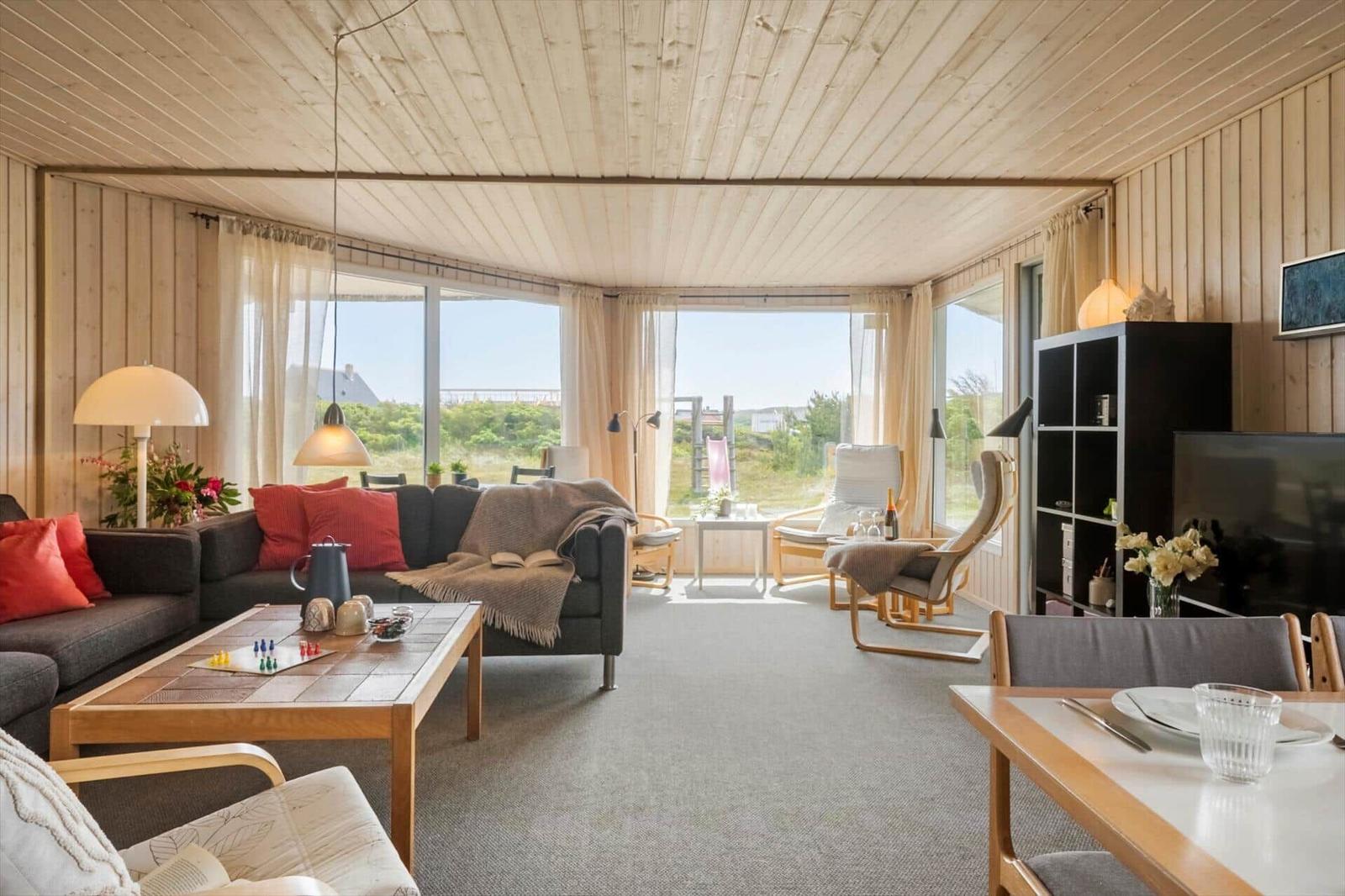 Wohnzimmer mit Sofa, Couchtisch und Blick auf Außenbereich.