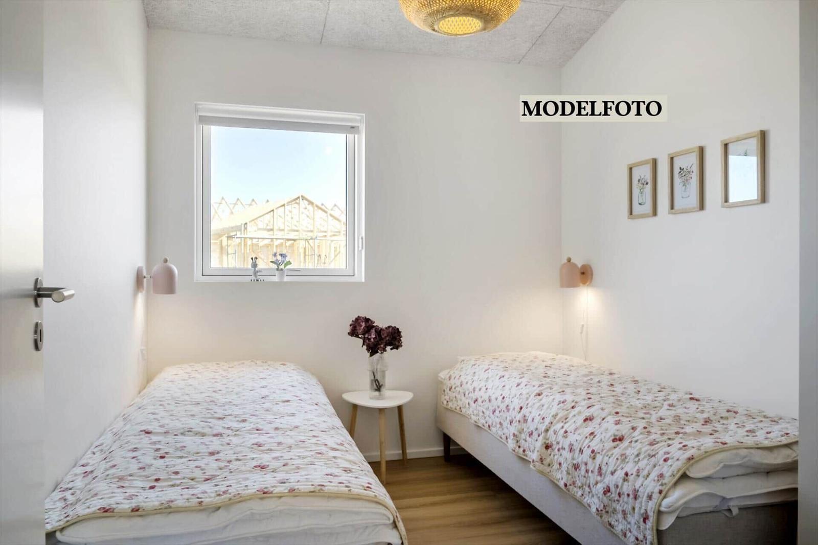 Zwei Einzelbetten mit Blumenbezug, Fenster und Wandbilder.
