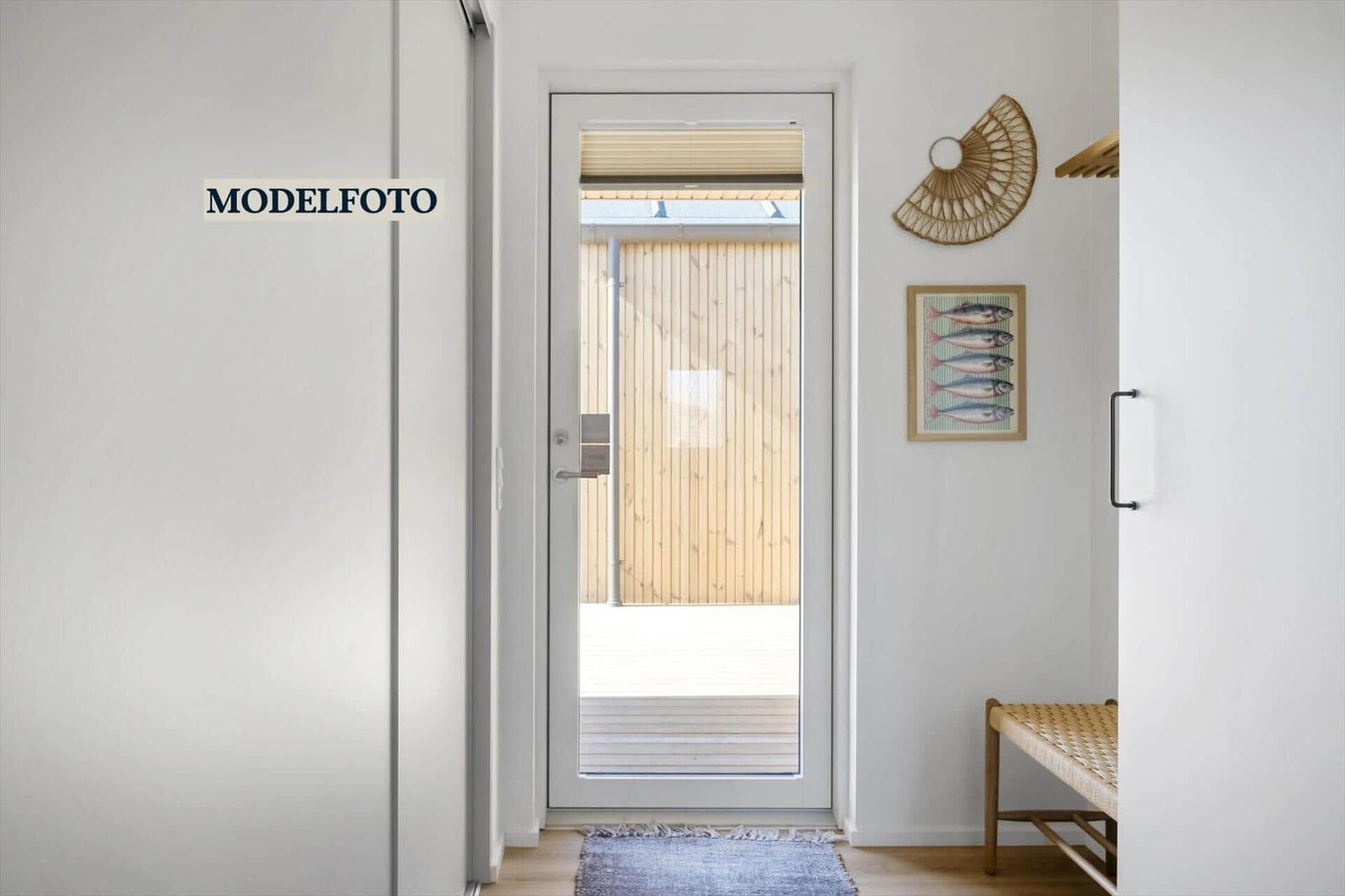 Eingangsbereich mit Glastür zu Balkon, Wanddekoration und Bänkchen