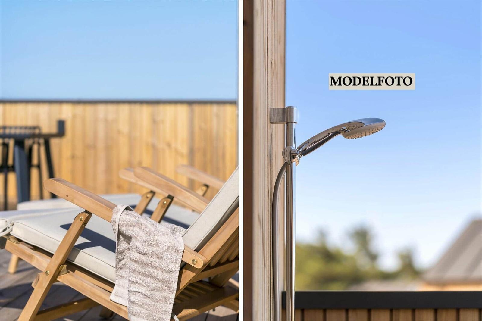 Terrasse mit Liegestühlen und Dusche im Freien
