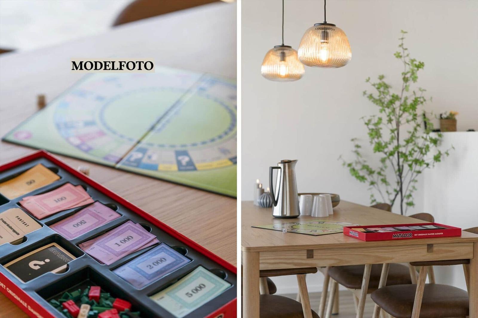 Tisch mit Spiel und Karten, Hängelampen und Pflanze im Essbereich