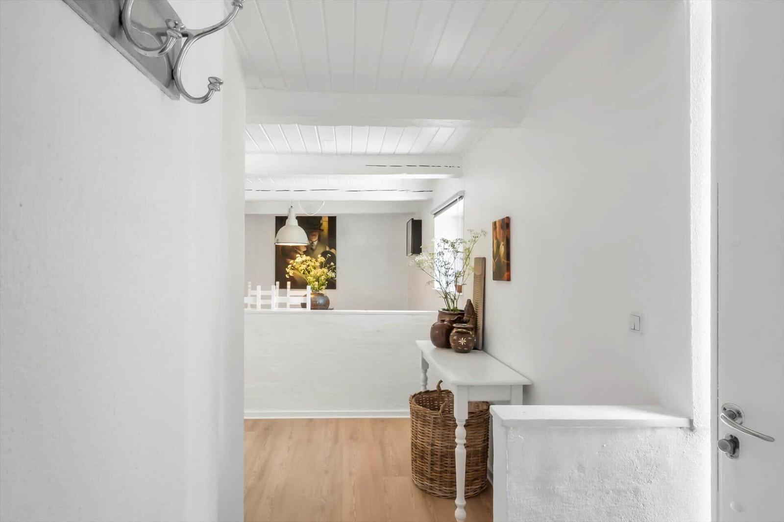 Haus mit weißem Interieur, Holzboden und dekorativen Elementen im Flur
