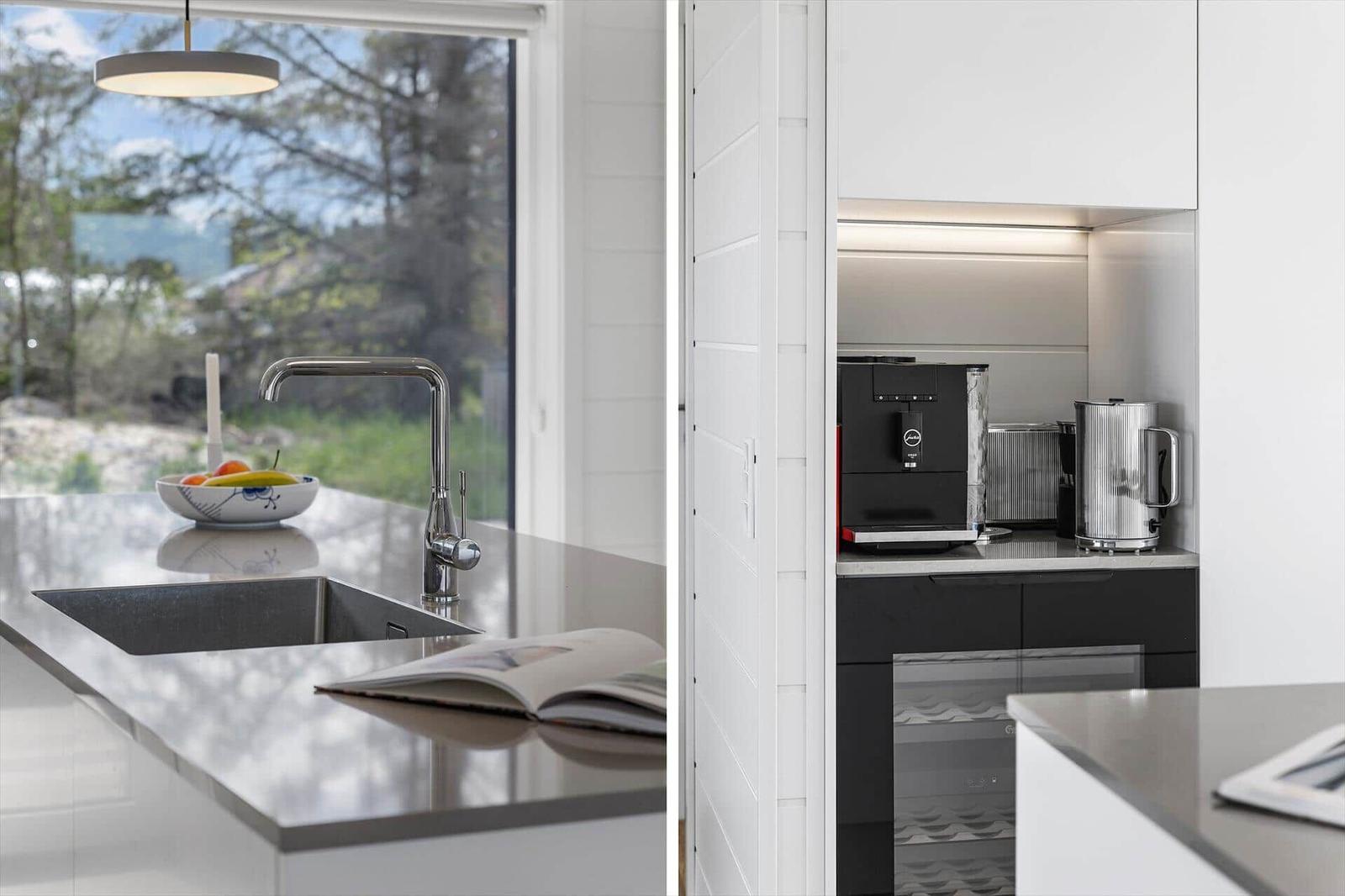 Küche mit Arbeitsplatte, Spüle und Fensterblick. Kaffeemaschine und Wasserkocher im Schrank.