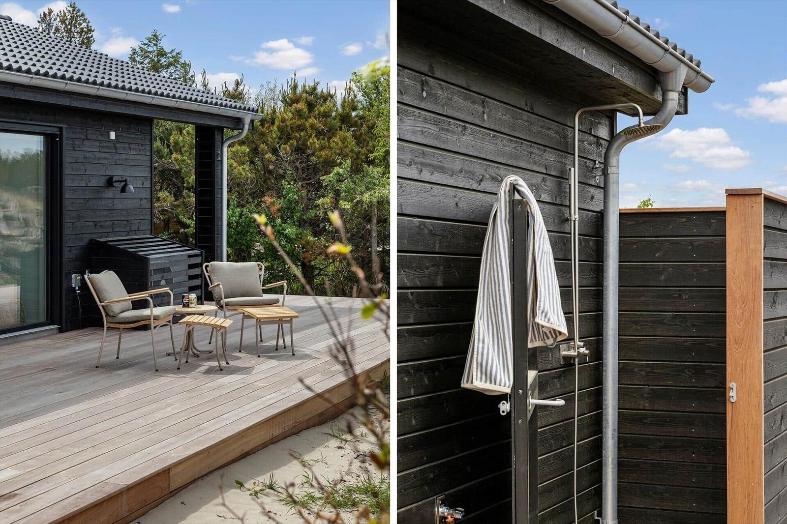 Terrasse mit Sitzgelegenheiten und Außendusche an der Hauswand.