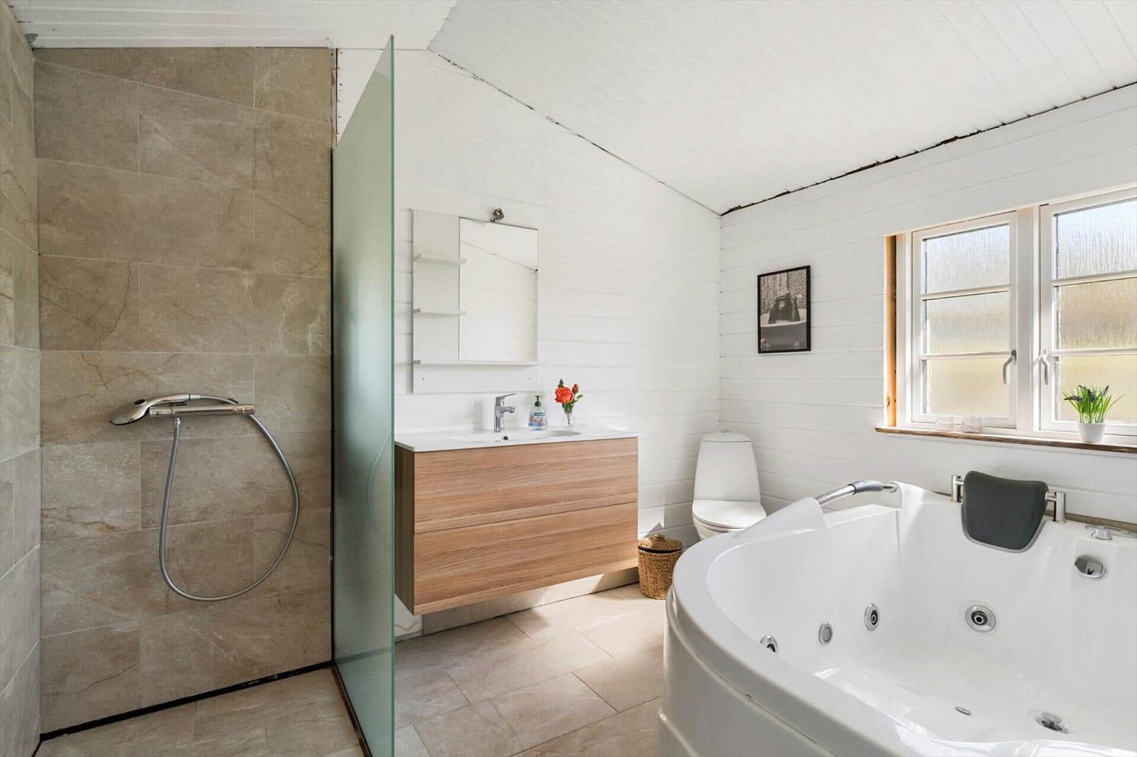 Badezimmer mit Dusche, Waschbecken und Whirlpoolbad