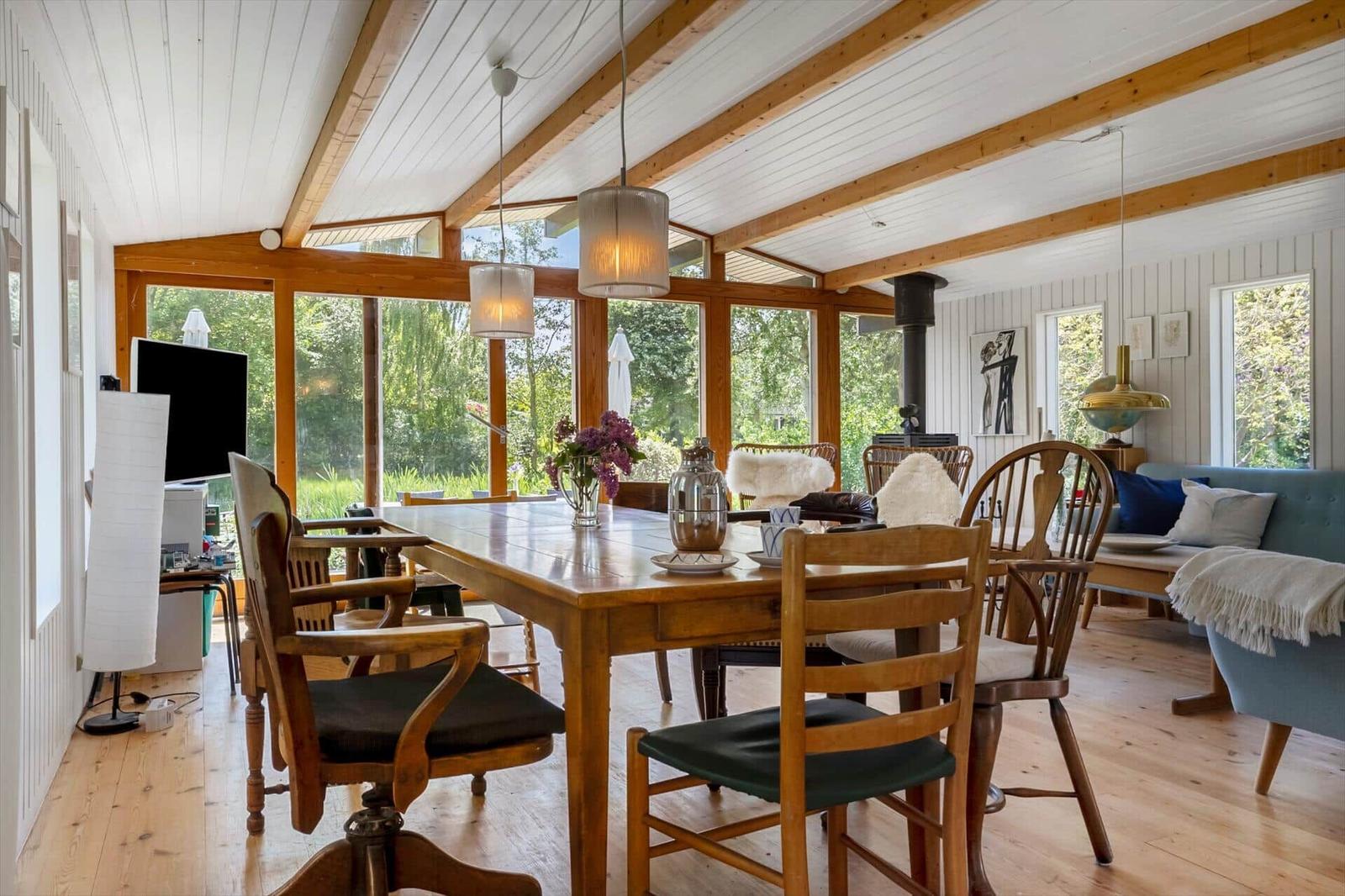 Dining room with wooden table, chairs, and view of garden