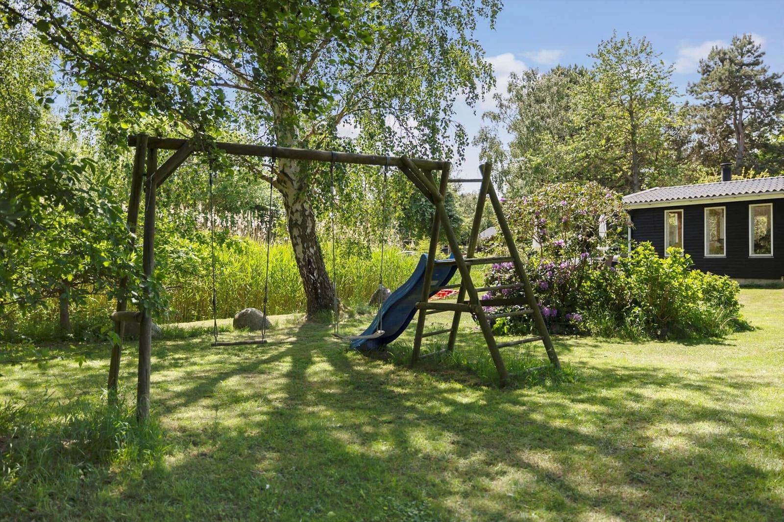 Behind the house is a playground with swing and slide.