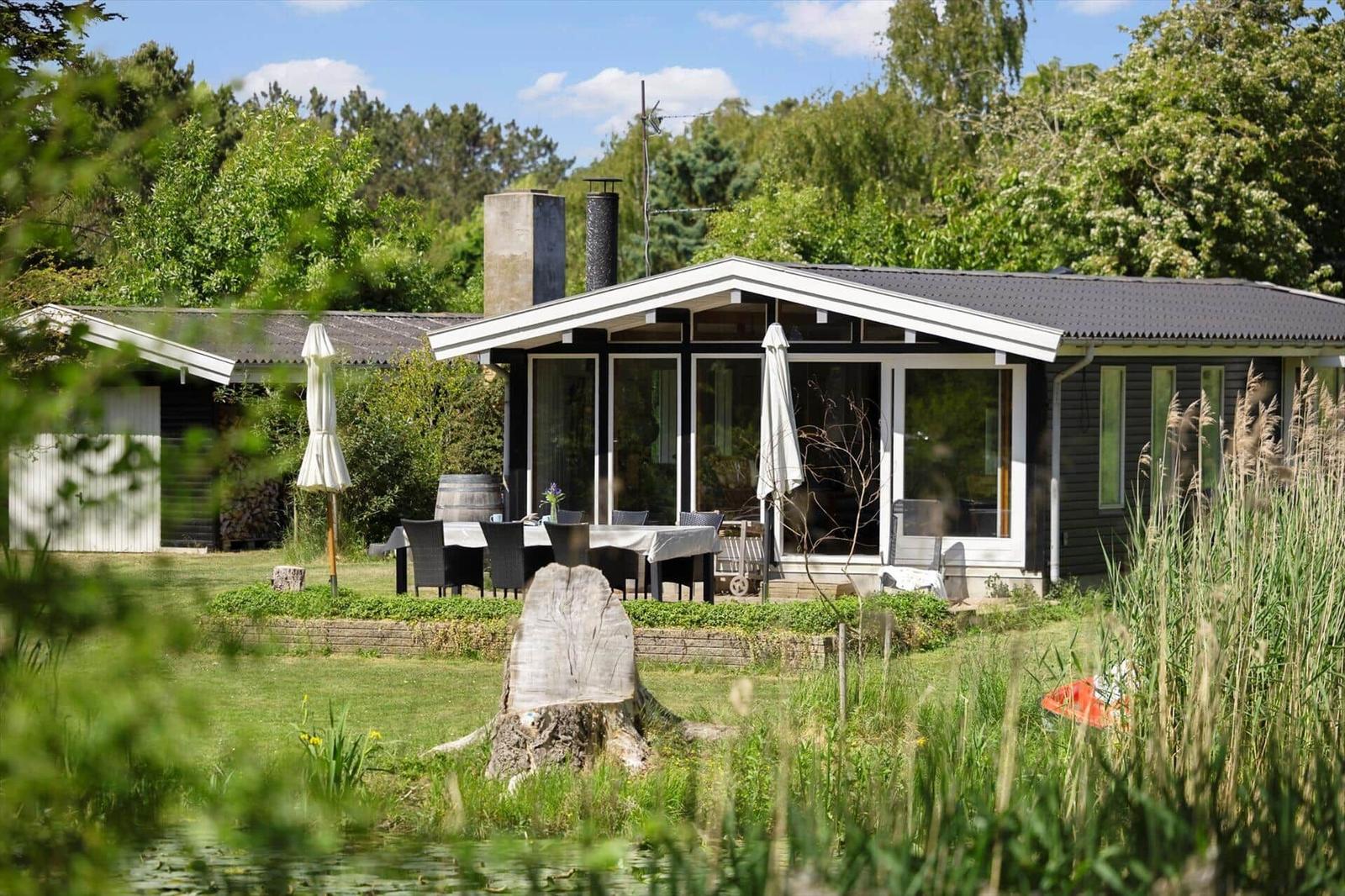 Modern villa with terrace, garden, and lake view. Grill area and sunshade available.