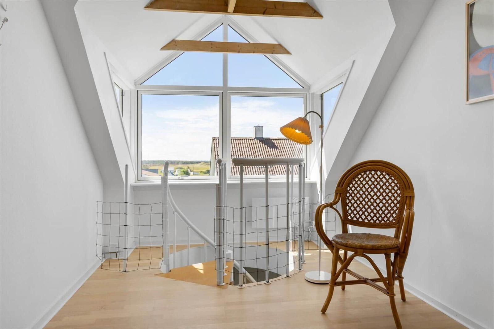Dachgeschoss mit Sitzgelegenheit und Blick auf Dächer.