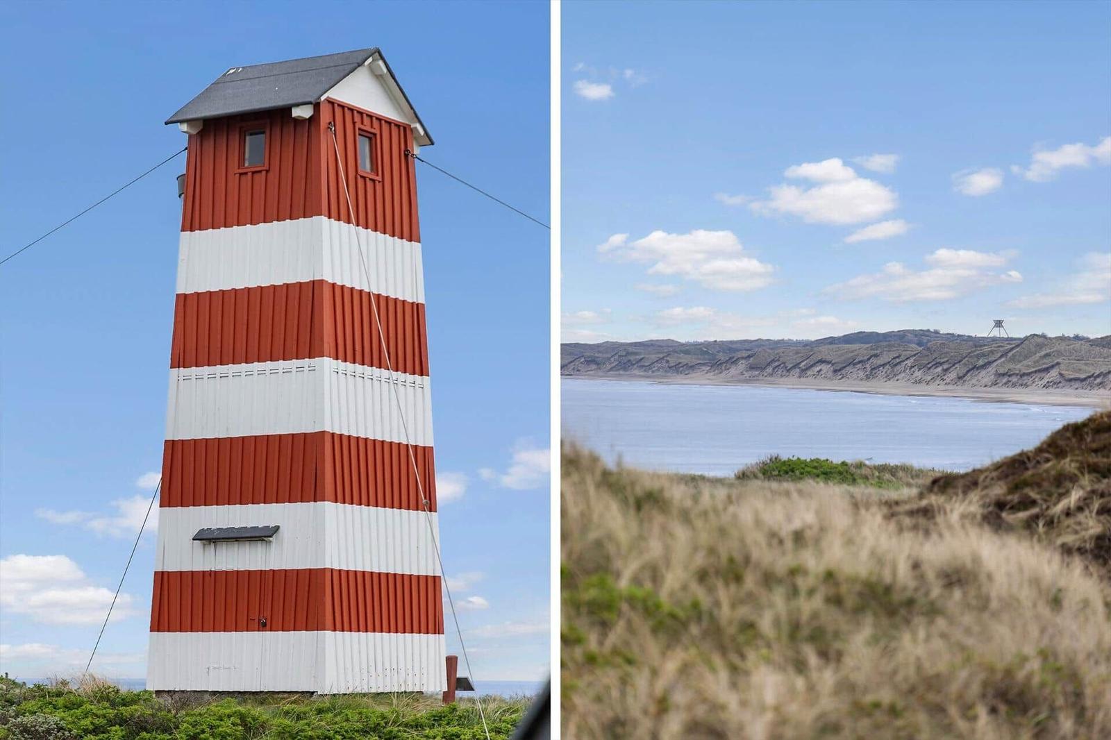 Roter Leuchtturm mit weißen Streifen und Blick auf die Küste mit Dünen.