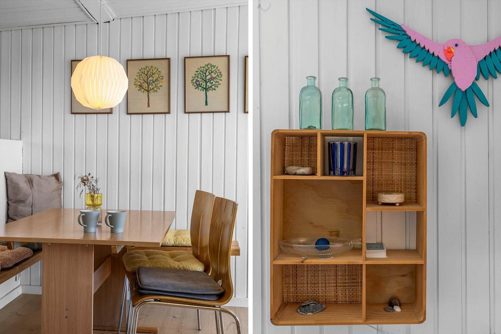 Essbereich mit Holztisch und Stühlen. Regal mit Vasen und Dekoration an der Wand.