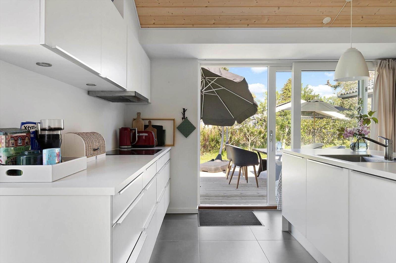 Kitchen with view to terrace with umbrella and chairs.