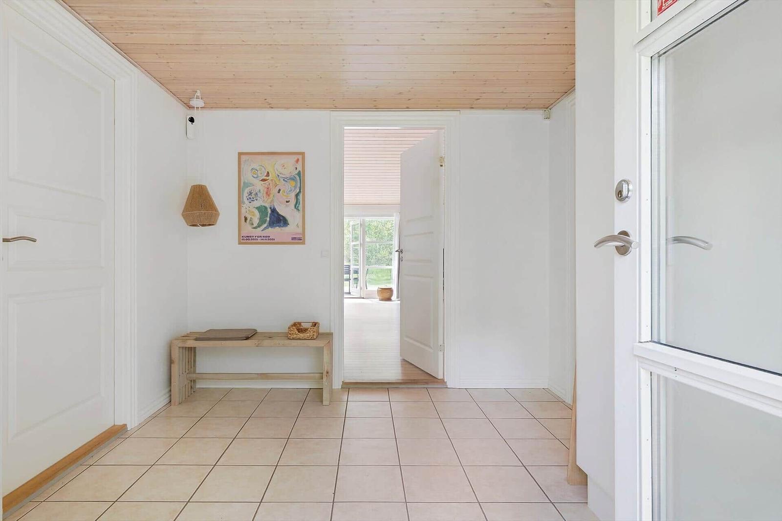 Entrance area with wooden ceiling, tiled floor, and door to outdoor area.
