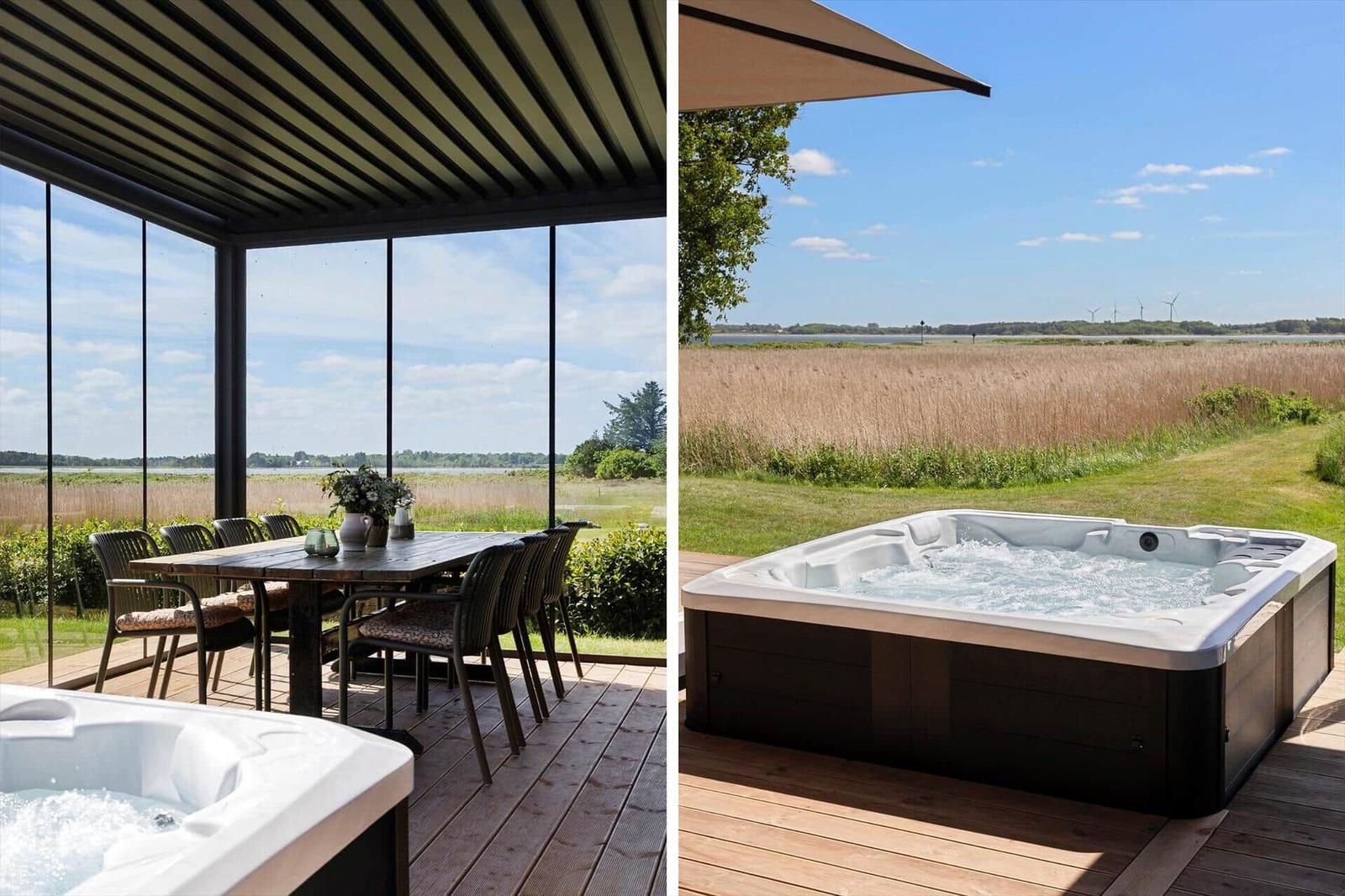 Deck with dining table and hot tub. View of fields and water.
