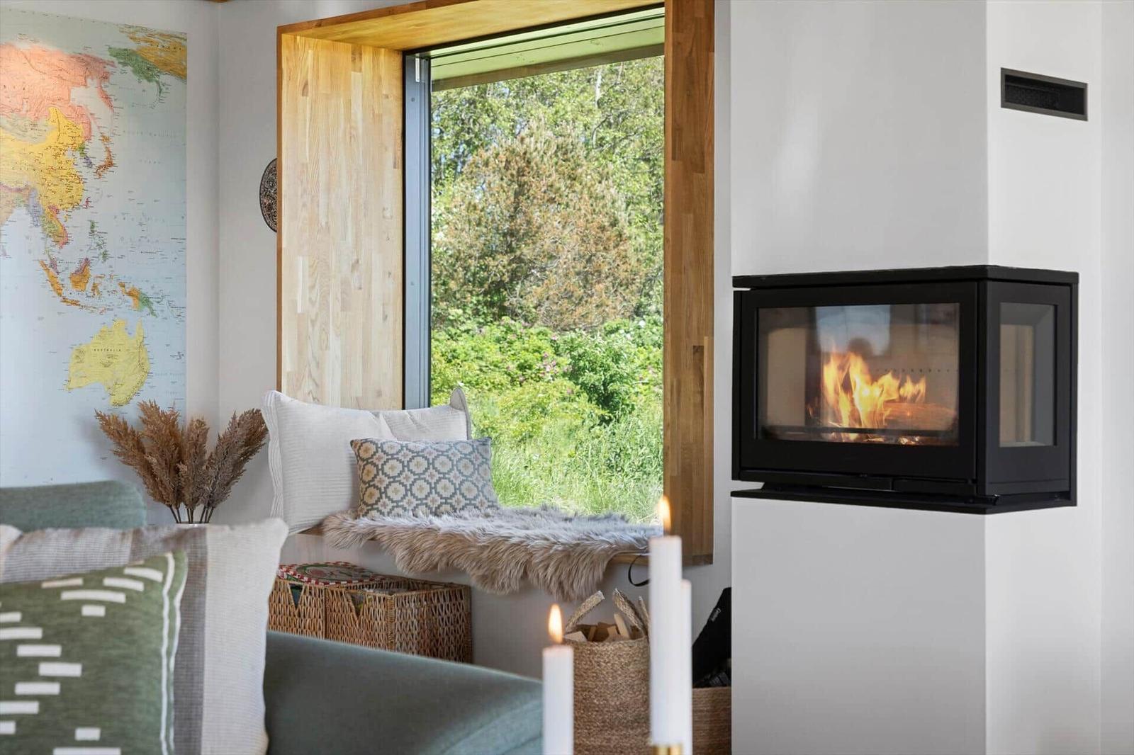A living room with fireplace, window seat, and world map on the wall.